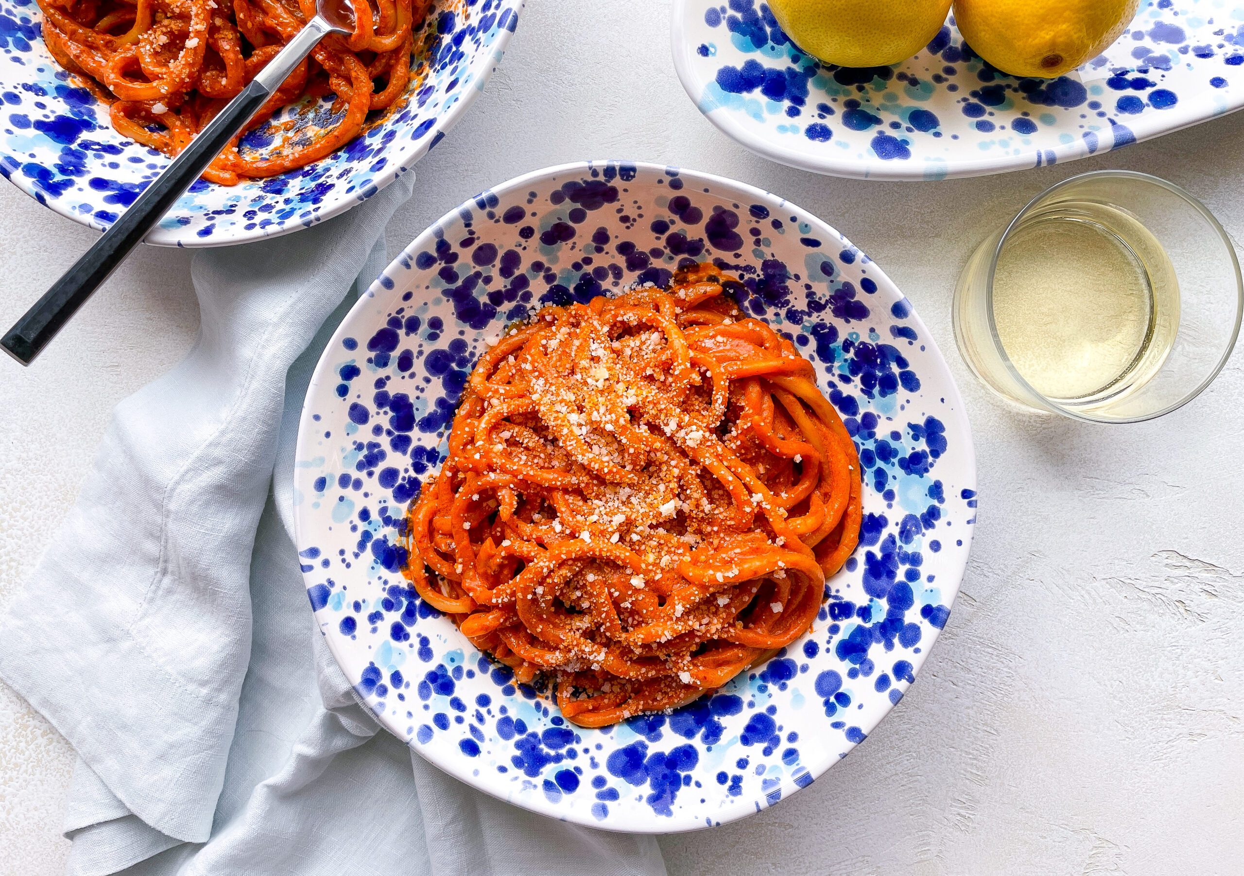 Spicy Tomato Pici (pasta al fumo) in a blue splatterware pasta bowl.