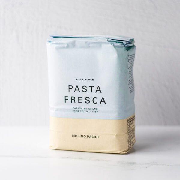 A bag of flour with the words "PASTA FRESCA Farina di Grano Tenero Tipo 00 Molino Pasini." The top two-thirds of the bag are light blue, the bottom third is tan.